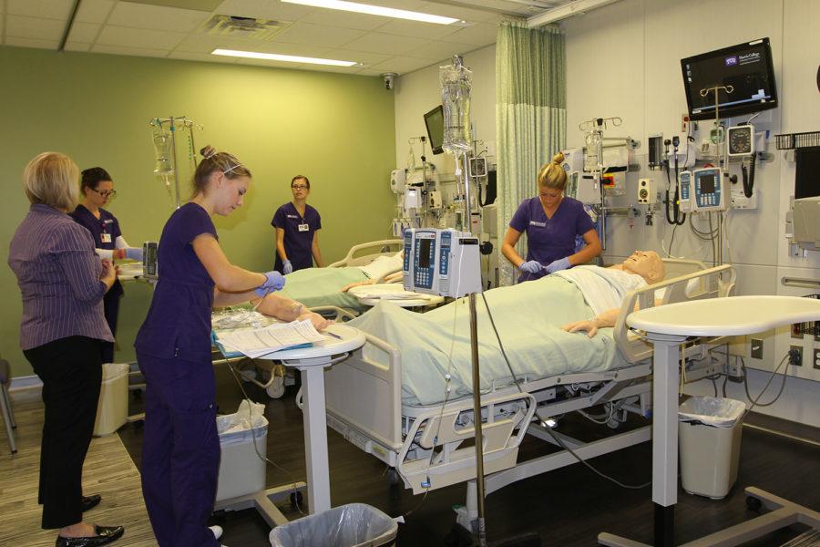 Students practice using IV infusion pumps under the supervision of Barbara Patten, assistant professor of professional practice at the simulation lab. Friday, Sept. 25, 2015.