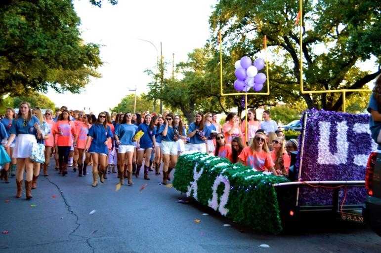 Students walk alongside the float built by Beta Theta Pi, Chi Omega and Alpha Delta Pi in the 2014 Homecoming Parade. (Kelsey Ritchie/TCU)
