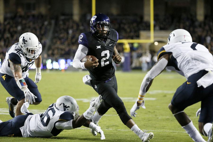 TCU quarterback Trevone Boykin (2) gets by  West Virginias Jared Barber (42) and Shaq Petteway, bottom, before leaping over cornerback Daryl Worley, right, into the end zone for a touchdown in the first half of an NCAA college football game Thursday, Oct. 29, 2015, in Fort Worth, Texas.  (AP Photo/Tony Gutierrez)
