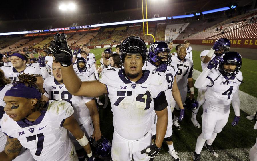 TCU offensive tackle Halapoulivaati Vaitai, center, celebrates with teammates after their 45-21 victory over Iowa State in an NCAA college football game, Saturday, Oct. 17, 2015, in Ames, Iowa. (AP Photo/Charlie Neibergall)