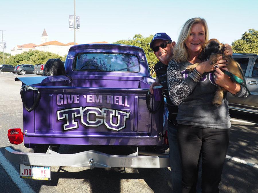 Frog Corps director Brad White, his wife Holly, and dog Bailey pose with the back end of their TCU styled truck. 