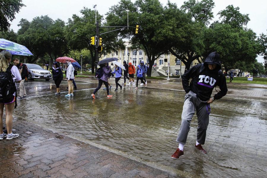 Students crossing South University Drive had to jump over the water build up on the edges of the street. (Alexandra Plancarte/TCU360)