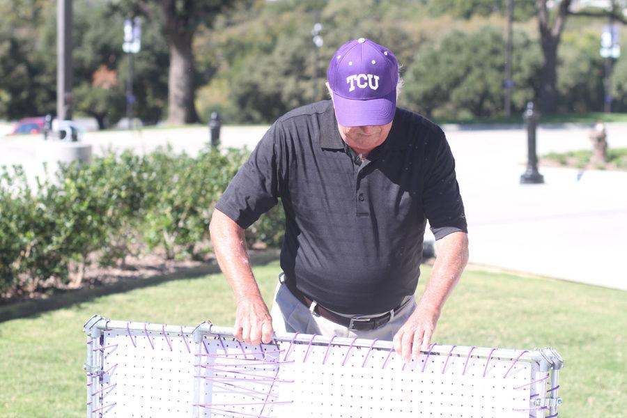 Charles Everly of Fort Worth, Texas, sets up his tailgate on the north side of Amon G. Carter Stadium