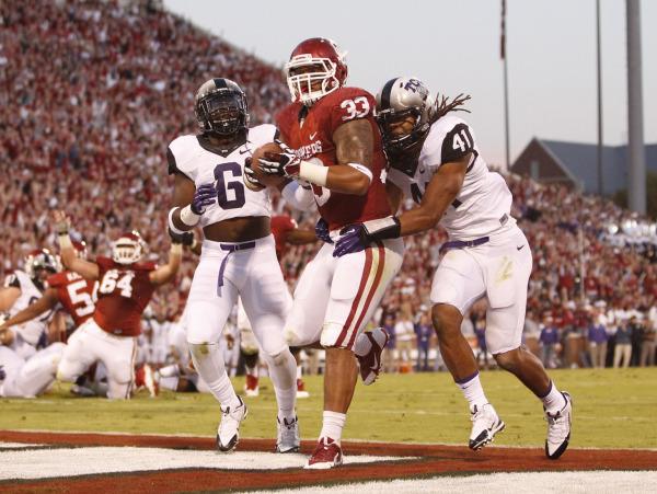 Oklahoma Sooners fullback Trey Millard (33) runs for a touchdown in the second quarter against the TCU Horned Frogs safety Elisha Olabode (6) and linebacker Jonathan Anderson (41) at Gaylord Family - Oklahoma Memorial Stadium on Oct. 5, 2013.