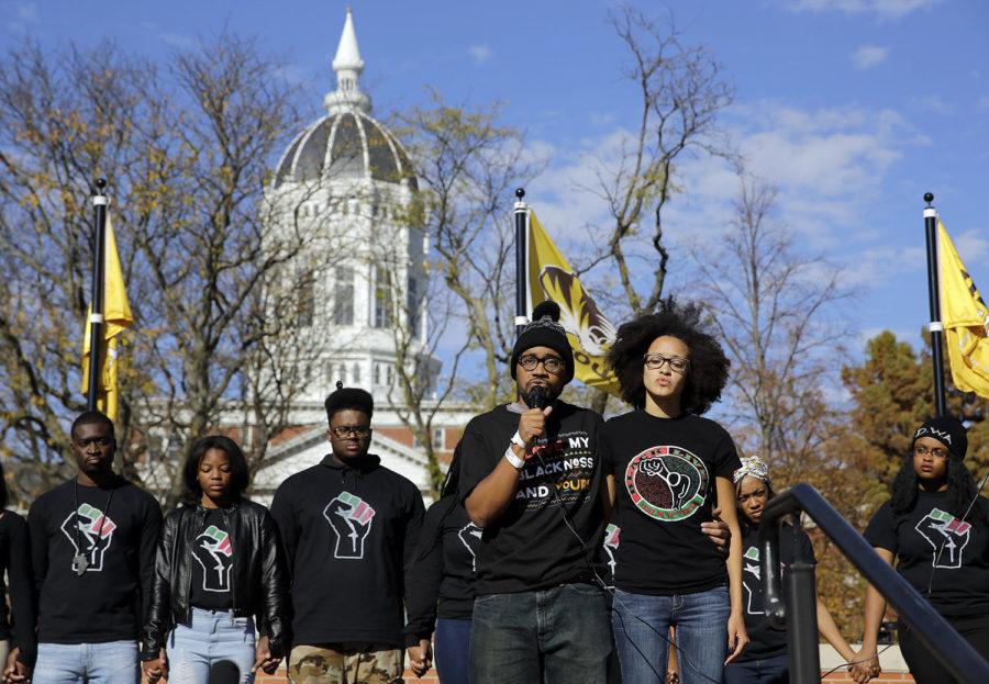 Jonathan Butler, front left, addresses a crowd following the announcement that University of Missouri System President Tim Wolfe would resign Monday, Nov. 9, 2015, at the university in Columbia, Mo. Butler has ended his hunger strike as a result of the resignation. (AP Photo/Jeff Roberson)