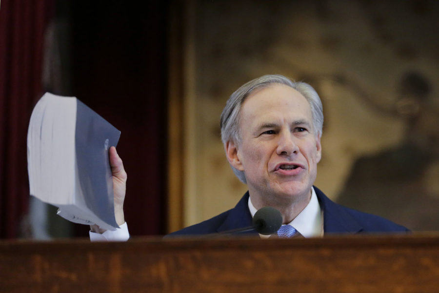 Texas Gov. Greg Abbott holds a book about Texas school laws as he delivers his State of the State address to a joint session of the House and Senate, Tuesday, Feb. 17, 2015, in Austin, Texas. (AP Photo/Eric Gay)