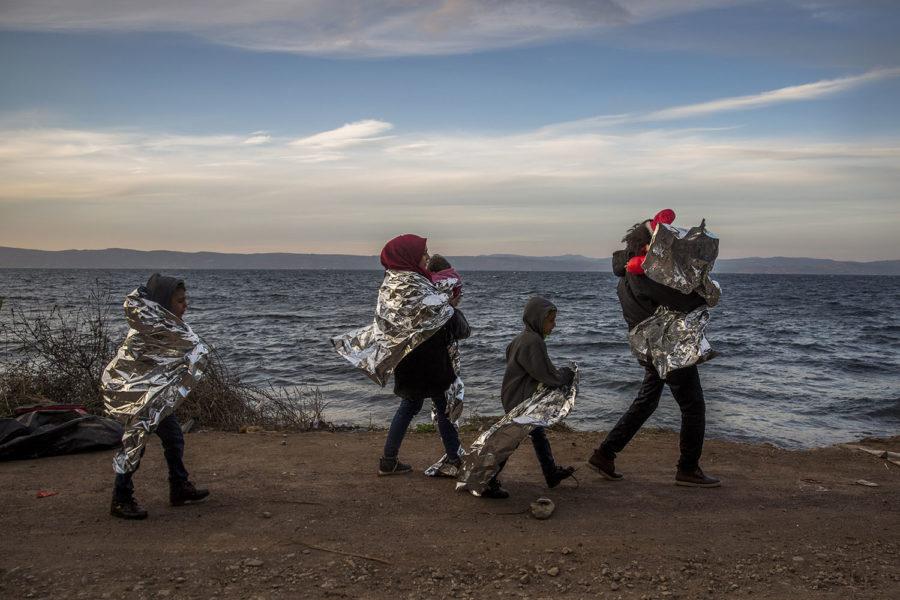 A Syrian family covered with thermal blankets walk after they arrived from Turkey at the Greek island of Lesbos, Tuesday, Oct. 27, 2015. (AP Photo/Santi Palacios)
