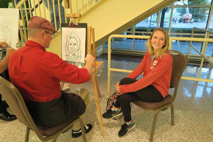 From left to right, Mathew Matty is a caricature artist from B3 Entertainment. Matty was working on cartoonish drawing of the student. 