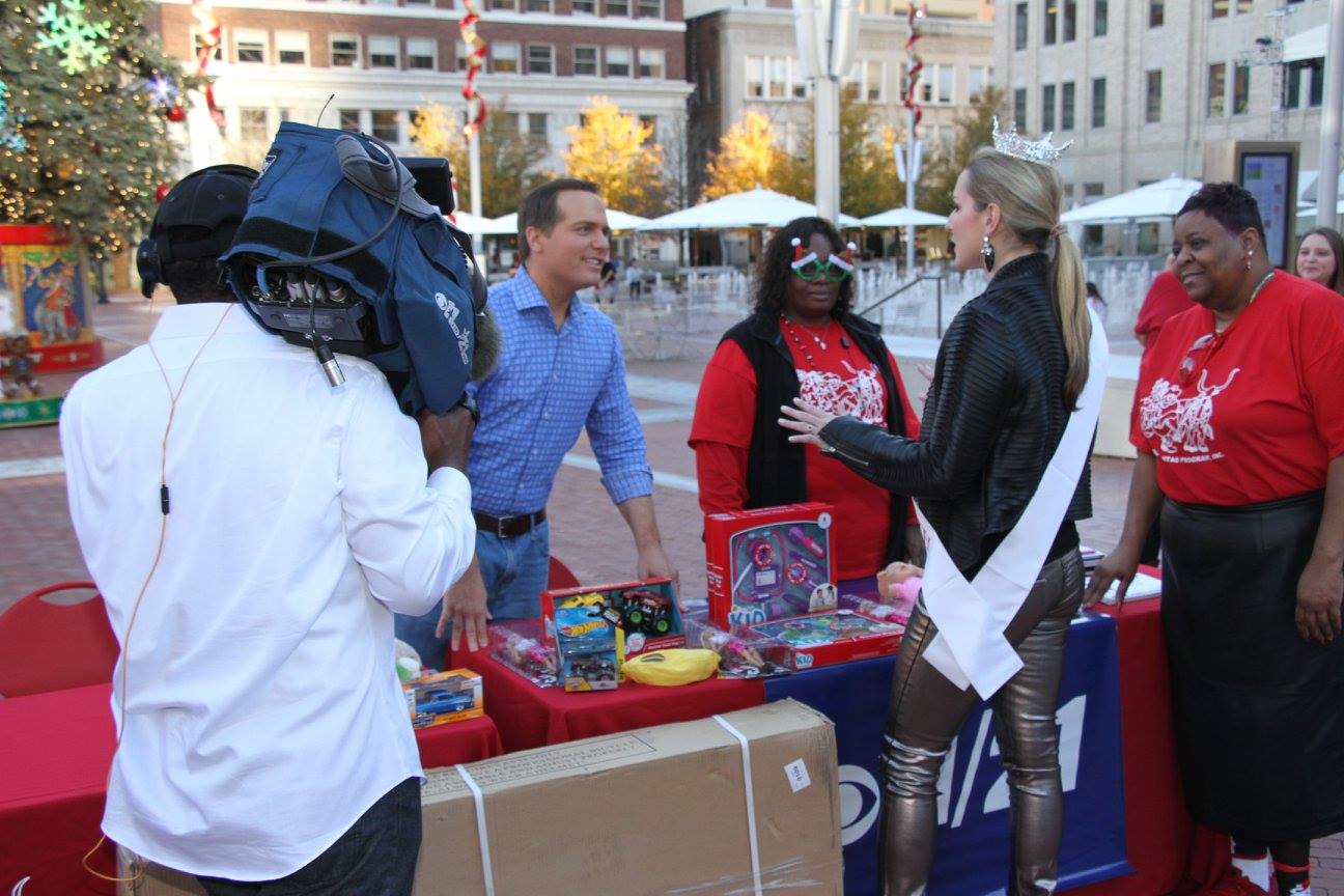 Tew speaking with CBS 11 meteorologist Larry Mowry at the Cowboys Santas event. 