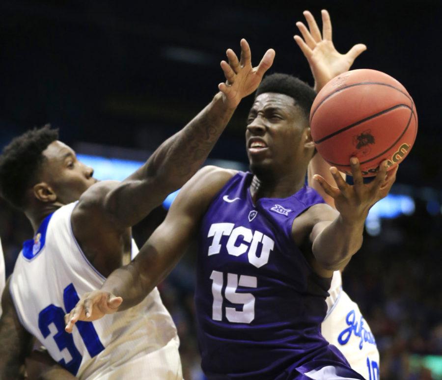 TCU forward JD Miller (15) shoots while pressured by Kansas forward Jamari Traylor (31) and guard Sviatoslav Mykhailiuk (10) during the second half of an NCAA college basketball game in Lawrence, Kan., on Jan. 16. 
