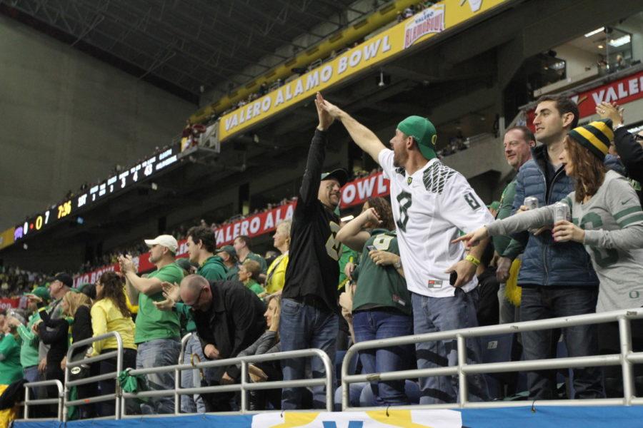 Oregon fans high five in the first half, when the Ducks shut out the TCU Frogs 31-0 in the 2016 Valero Alamo Bowl in the San Antonio Alamodome on Jan. 2, 2016.