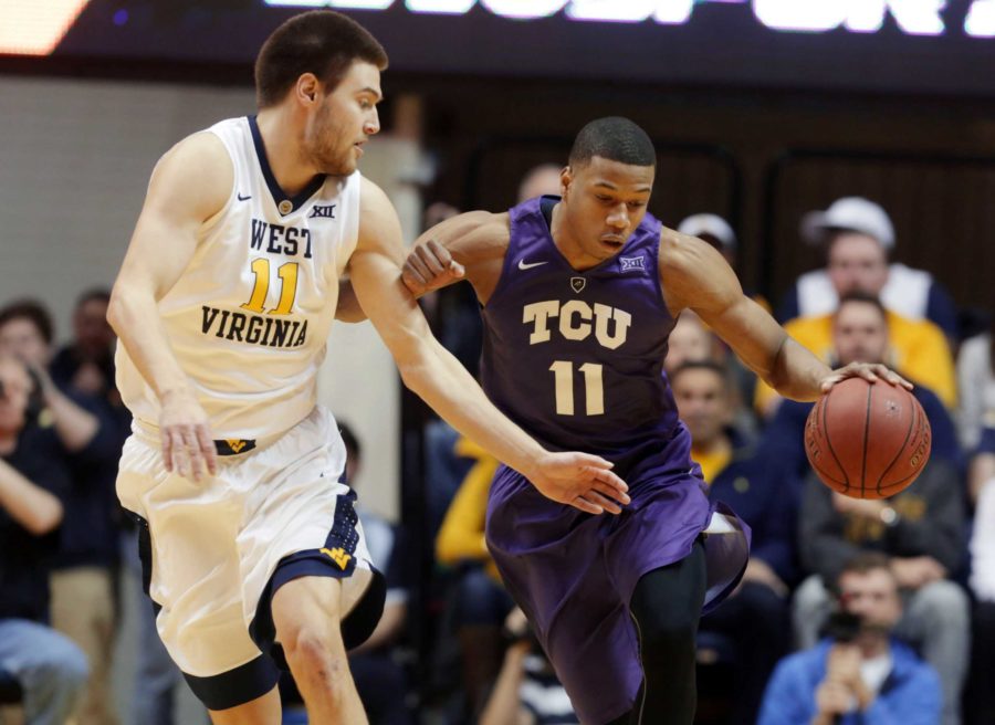 TCU guard Brandon Parrish (11) drives up court while being guarded by West Virginia forward Nathan Adrian (11) on Feb. 13. 