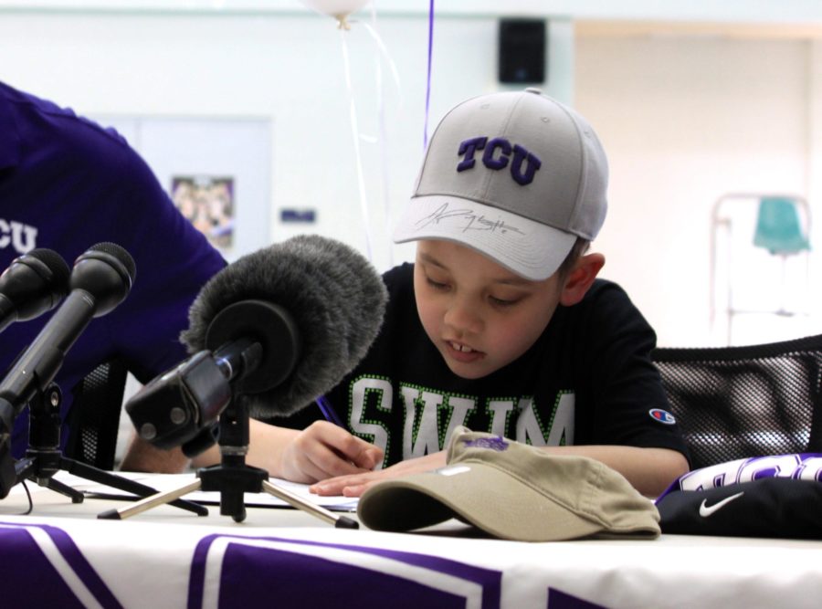 Eight-year-old+Nathan+Lin+signs+to+become+an+honorary+member+of+the+TCU+swimming+%26+diving+program.