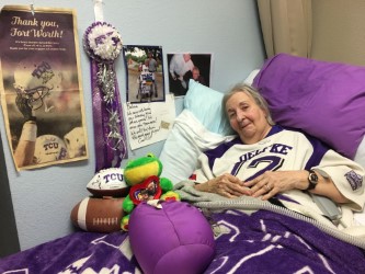 Dolores Oelfke lays in her TCU themed bed at Mira Vista Nursing Home.