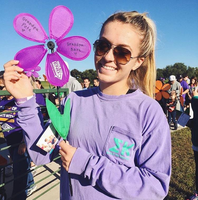Freshman Tess Clausen holds a purple flower in memory of her Grandpa Pete who she and her family lost to Alzheimer's (Photo courtesy: Alzheimer's Association North Central Texas Chapter).