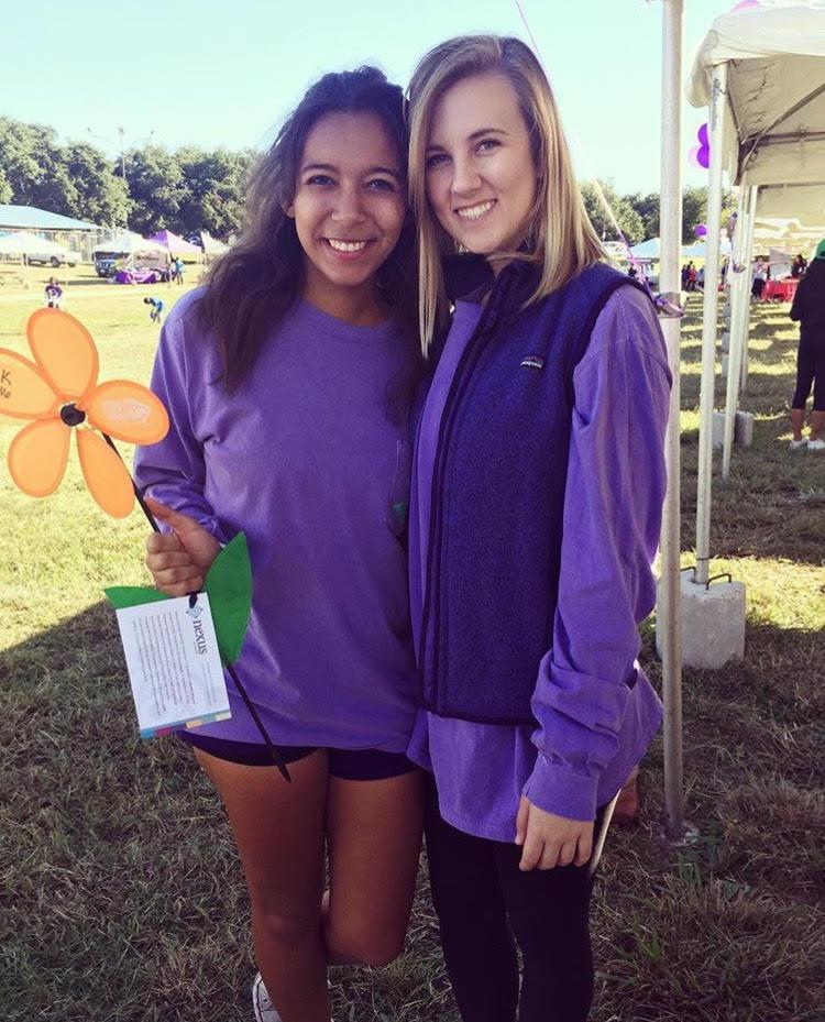 Sigma Kappa sophomore Alexis Hood holds an orange flower which represents her support for the Alzheimer's cause as she stands next to her sorority sister, sophomore Haley Decker (Photo courtesy: Alzheimer's Association North Central Texas Chapter).