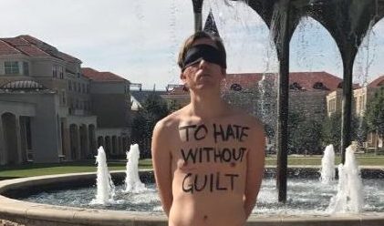 A TCU male student stands in front of Frog Fountain, silently protesting with To hate without guilt on his chest. (Photo Credit: Kamry Henson)