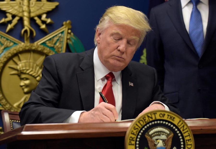President Donald Trump signs an executive order on extreme vetting during an event at the Pentagon in Washington, Friday, Jan. 27, 2017. (AP Photos/Susan Walsh)