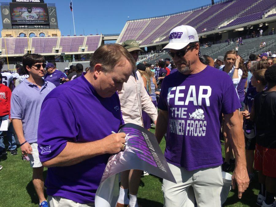 TCU head coach Gary Patterson signs a fans poster after the annual spring game on Saturday. 