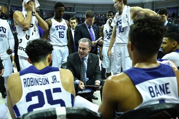 TCU head coach Jamie Dixon talks strategy with his team during a timeout. (Photo courtesy of GoFrogs.com)