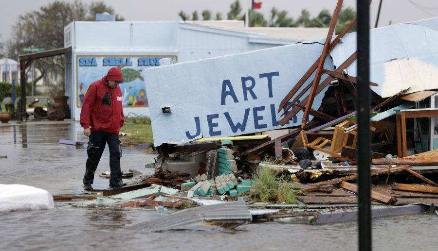 A member of the media walks past a business that was destroyed by Hurricane Harvey, Saturday, Aug. 26, 2017, in Rockport, Texas. (AP Photo/Eric Gay)