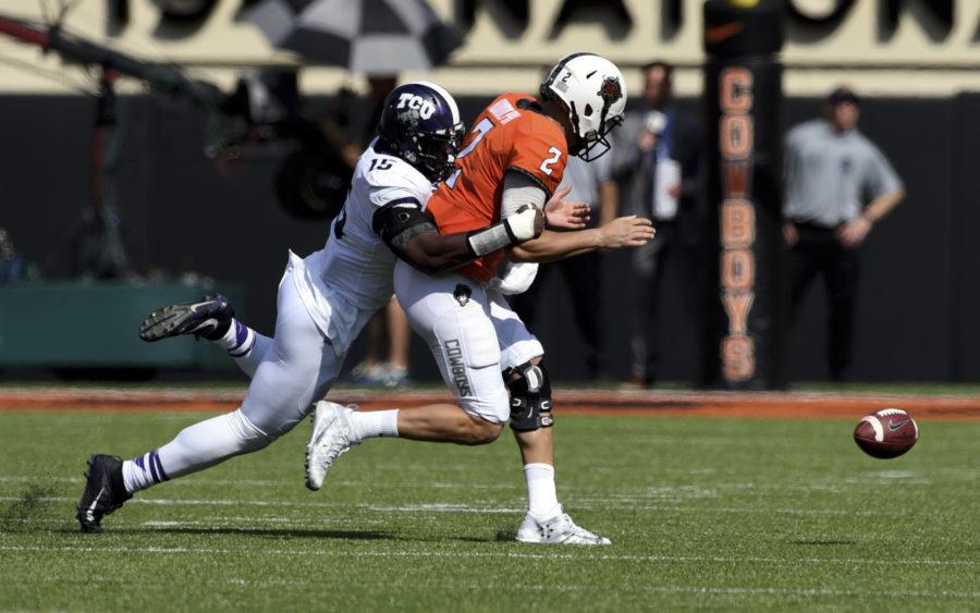 TCU defensive end Ben Banogu, left, forces a fumble by Oklahoma State quarterback Mason Rudolph, during the first half of an NCAA college football game in Stillwater, Okla., Saturday, Sept. 23, 2017.(AP Photo/Brody Schmidt)