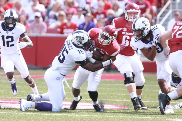 TCU defensive end Ben Banogu (15) tackles Arkansas running back David Williams. Photo courtesy of GoFrogs.com