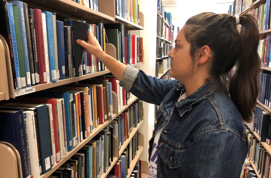 Junior Film, Television, and Digital Media major Sarah Persson checks out a book in the library. (Photo by Elizabeth Hinz.) 