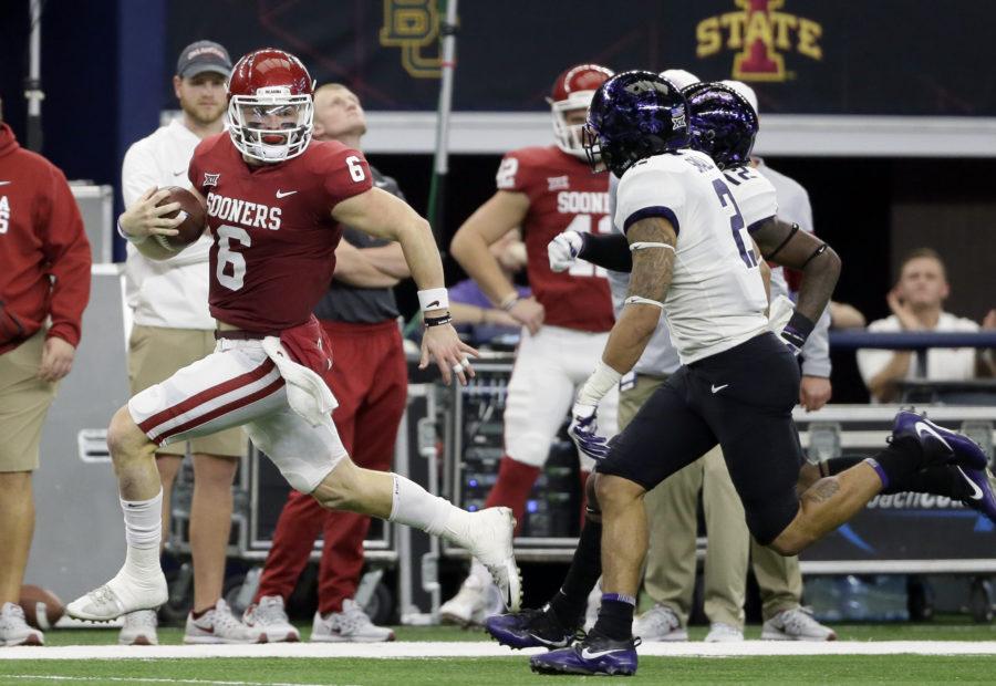 Oklahoma quarterback Baker Mayfield, left, gains yardage as he runs the ball as TCU safety Niko Small (2) gives chase in the first half of the Big 12 Conference championship NCAA college football game, Saturday, Dec. 2, 2017, in Arlington, Texas. (AP Photo/Tony Gutierrez)