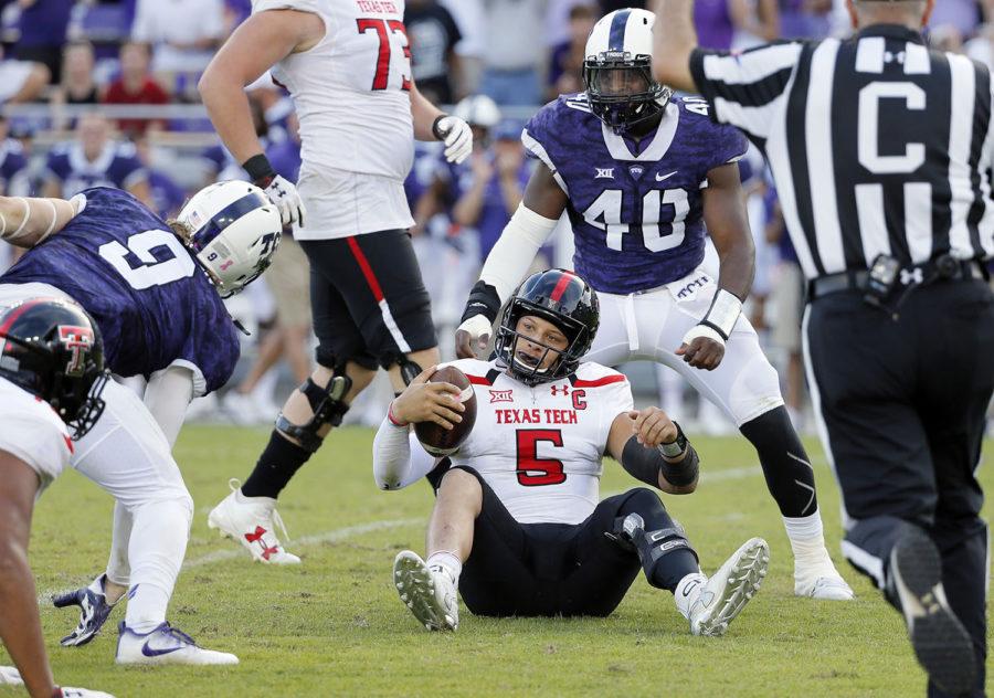 Texas Tech quarterback Patrick Mahomes II (5) sits on the ground after being sacked by TCU defensive end Mat Boesen (9) and defensive end James McFarland (40) in the second half of an NCAA college football game, Saturday, Oct. 29, 2016, in Fort Worth, Texas. (AP Photo/Tony Gutierrez)