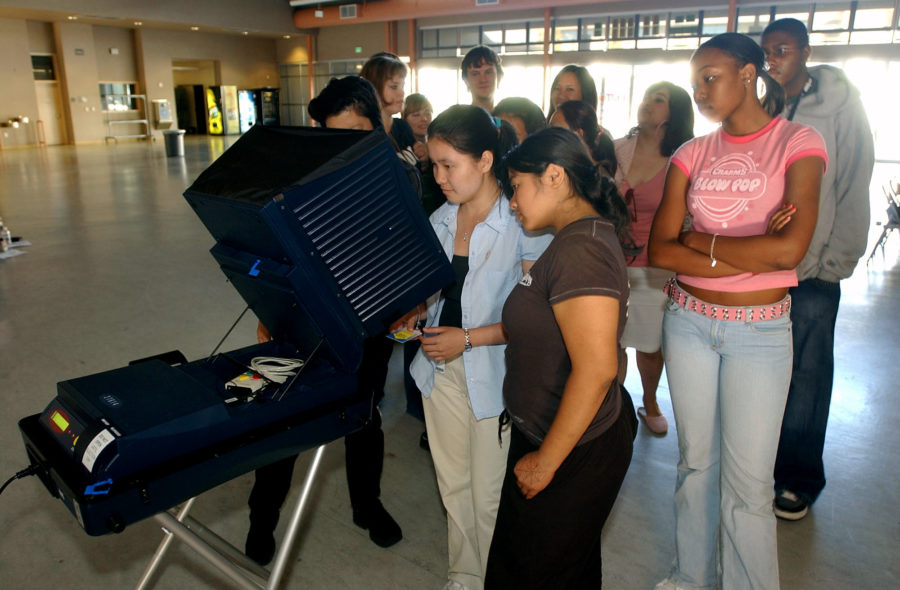 Evergreen Valley high school students learn to use a touch screen voting machine during a training sesssion to prepare them to work the polls on the schools campus in San Jose, Calif. on Thursday, Oct. 7, 2004.  The students _ most too young to vote _ will serve as poll workers in San Jose.    U.S. polling places are facing a record shortage of poll workers, and many election experts are warning voters that they may face long lines, cranky staffs, equipment breakdowns, problems opening and closing voting stations and other hassles. Counties are trying to cope with the problem by last-minute recruiting and training sessions and creative recruitment drives.  (AP Photo/Marcio Jose Sanchez)