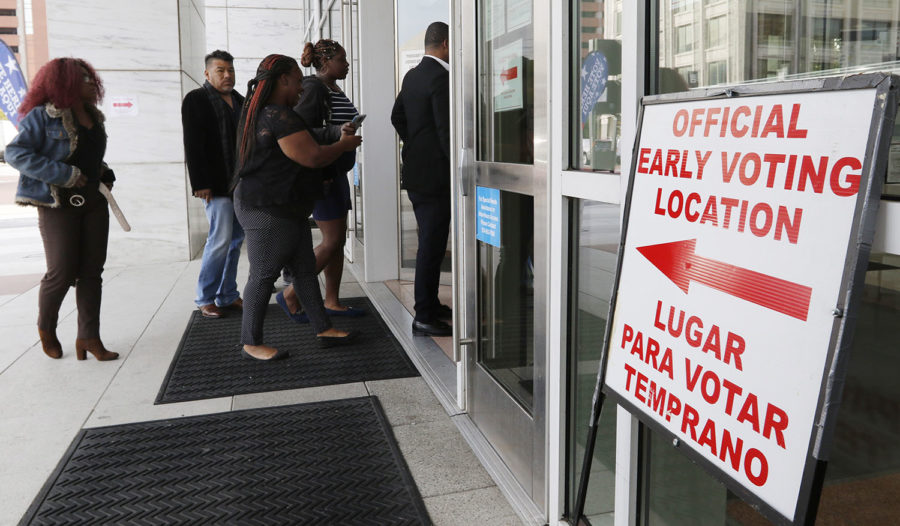 People walk into the George L. Allen, Sr. Courts Building in Dallas on Monday, Oct. 22, 2018. Early voting starts Oct. 22 and ends Nov. 2. (Irwin Thompson/The Dallas Morning News via AP)