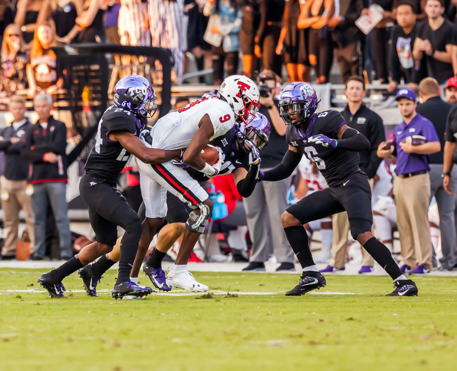 Julian Lewis, Innis Gaines, and Garrett Wallow combine for a tackle against Texas Tech. Photo by Cristian ArguetaSoto.