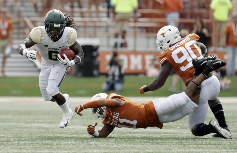 Baylor running back JaMycal Hasty (6) runs past the grasp of Texas defensive back P.J. Locke III (11) during the first half of an NCAA college football game, Saturday, Oct. 13, 2018, in Austin, Texas. (AP Photo/Eric Gay)