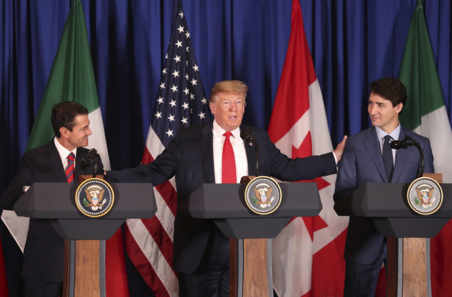 President Donald Trump, center, reaches out to Mexicos President Enrique Pena Nieto, left, and Canadas Prime Minister Justin Trudeau as they prepare to sign a new United States-Mexico-Canada Agreement that is replacing the NAFTA trade deal, during a ceremony at a hotel before the start of the G20 summit in Buenos Aires, Argentina, Friday, Nov. 30, 2018. The USMCA, as Trump refers to it, must still be approved by lawmakers in all three countries. (AP Photo/Martin Mejia)