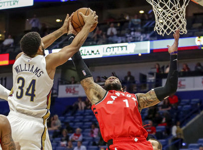 New Orleans Pelicans guard Kenrich Williams (34) and Toronto Raptors center Eric Moreland (1) reach for a rebound during the second half of a preseason NBA basketball game in New Orleans, Thursday, Oct. 11, 2018. The Raptors won 134-119. (AP Photo/Scott Threlkeld)