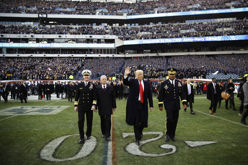 President Donald Trump, center right, accompanied by Secretary of Defense Jim Mattis, center left, waves as they walk on the field before of an NCAA college football game between Army and Navy, Saturday, Dec. 8, 2018, in Philadelphia. (AP Photo/Matt Rourke)