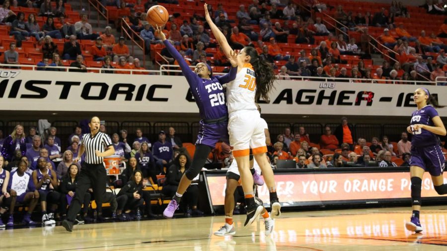 TCU guard Lauren Heard lays-in a contested bucket at the rim over an Oklahoma State defender. Photo courtesy of GoFrogs.com