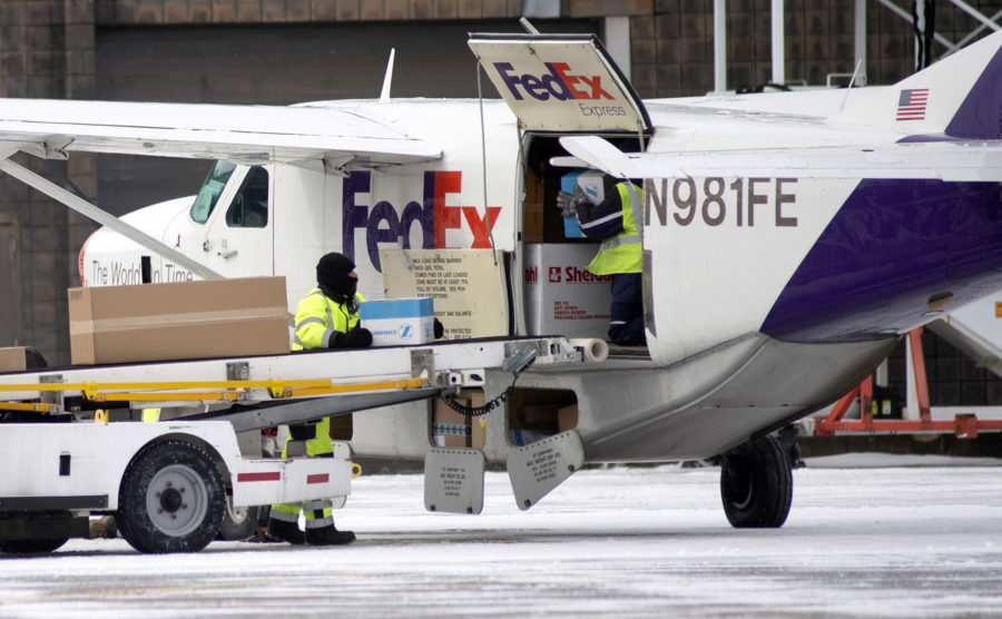 Workers load packages for a FedEx flight out of Pittsburgh International Airport, Wednesday, Jan. 30, 2019 in Moon, Pa. Dangerously low wind chills closed many area schools and government offices. (Pam Panchak/Pittsburgh Post-Gazette via AP)