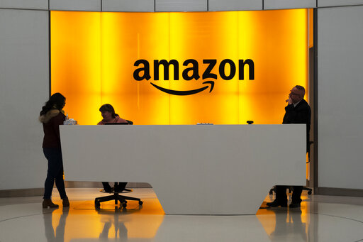 People stand in the lobby for Amazon offices Thursday, Feb. 14, 2019, in New York. Amazon will not build a new headquarters in New York City, a stunning reversal to an ambitious plan that would have brought an estimated 25,000 jobs to the city. (AP Photo/Mark Lennihan)