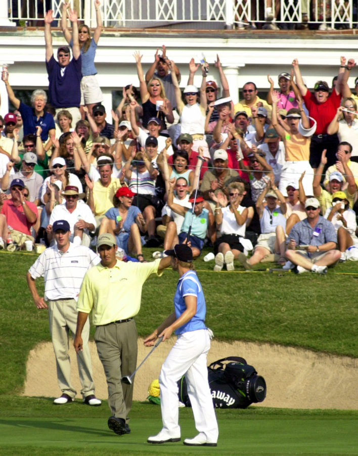 The gallery cheers and yells as golfer Annika Sorenstam is congratulated by her playing partners, Aaron Barber, left, and Dean Wilson, after she completed play on the18th hole of the Colonial Country Club in Fort Worth, Texas on Friday, May 23, 2003.  She was competing in the second round of the Colonial Invitational Tournament and failed to make the cut. (AP Photo/Amy Conn-Gutierrez)
