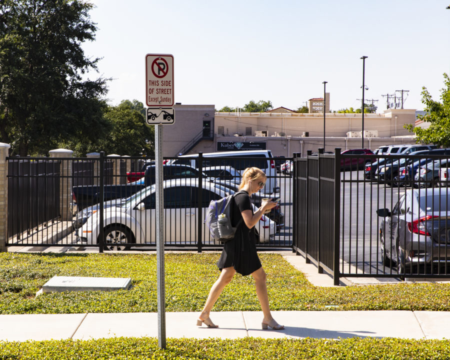 A student walking past an on-campus parking lot. Photo by Heesoo Yang. 