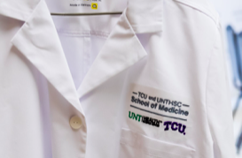 TCU and UNTHSC white coats on display at the TCU and UNTHSC School of Medicine announcement event. Photo by Cristian Argueta Soto.