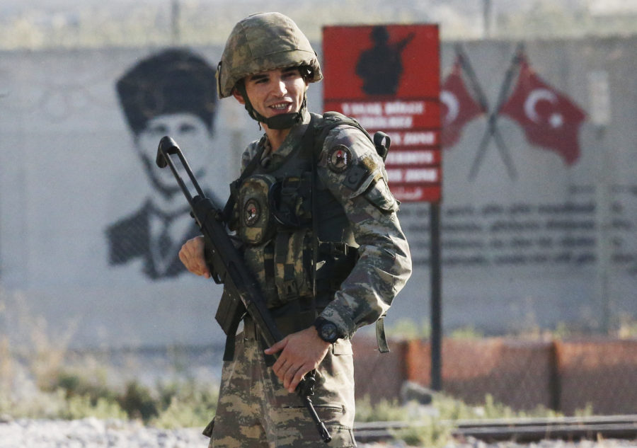 A Turkish soldier stands at the border Wednesday against Kurdish fighters from the area. (AP Photo/Lefteris Pitarakis)