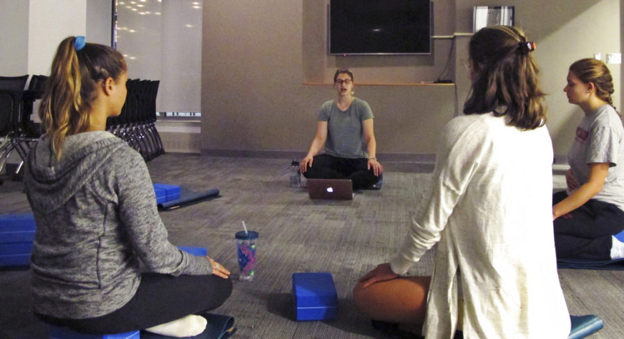In this Sept. 12, 2017 photograph, students at the University of Vermont in Burlington, Vt., take a meditation class in a new Wellness Environment dormitory. The university has opened a dorm that goes beyond mere bans on drugs and alcohol to promote overall healthy lifestyles. Students meditate, practice yoga, eat well and make other healthy choices in the Wellness Environment. (AP Photo/Lisa Rathke)