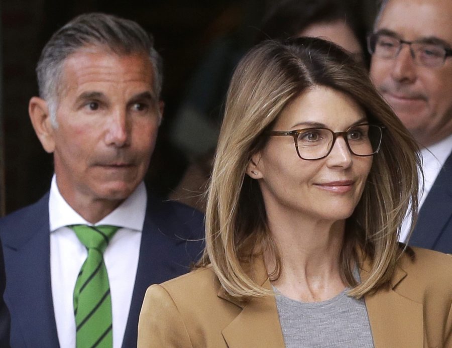 FILE - In this April 3, 2019, file photo, actress Lori Loughlin, front, and her husband, clothing designer Mossimo Giannulli, left, depart federal court in Boston. Lawyers for Loughlin and Giannulli said Wednesday, Feb. 26, 2020 that new evidence shows the couple is innocent of charges that they bribed their daughters way into the University of Southern California.  (AP Photo/Steven Senne, File)