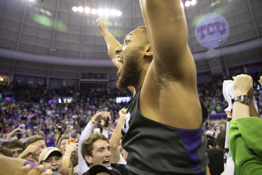 Edric Dennis Jr. (2) raises his arm in victory as students and players storm the court to celebrate beating No. 2 Baylor.
Photo by Heesoo Yang