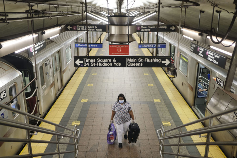 A commuters walks on a nearly empty subway platform in New York, Monday, June 8, 2020. After three months of a coronavirus crisis followed by protests and unrest, New York City is trying to turn a page when a limited range of industries reopen Monday. (AP Photo/Seth Wenig)