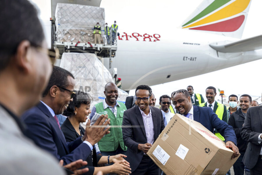 National Coordinator Dr Shumete Gizaw, center-right, hands over a box of medical supplies to Minister of Health Dr Lia Tadesse, center-left, after a cargo flight containing over 6 million medical items including face masks, test kits, face shields and protective suits arrived in the capital Addis Ababa, Ethiopia Sunday, March 22, 2020. The supplies arriving from Guangzhou, China for fighting the spread in Africa of the COVID-19 coronavirus were donated by the Jack Ma Foundation and Alibaba Foundation and will be distributed from Ethiopia to countries throughout Africa.(AP Photo/Mulugeta Ayene)