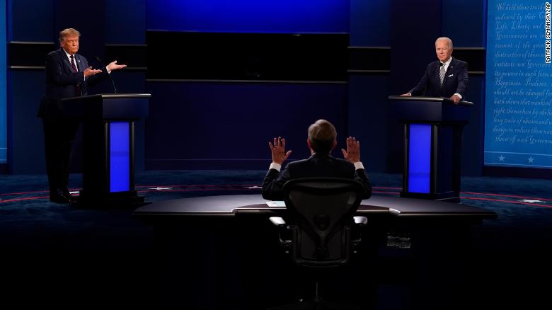 Moderator Chris Wallace of Fox News, center, gesturing during the first presidential debate between President Donald Trump, left, and Democratic presidential candidate former Vice President Joe Biden, right, Tuesday, Sept. 29, 2020, at Case Western University and Cleveland Clinic, in Cleveland, Ohio. (AP Photo/Patrick Semansky)
